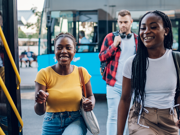 Three teenagers getting on a bus