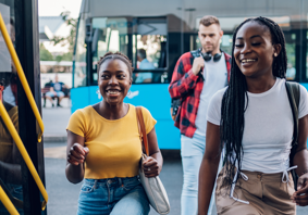 Three teenagers getting on a bus