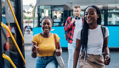 Three teenagers getting on a bus