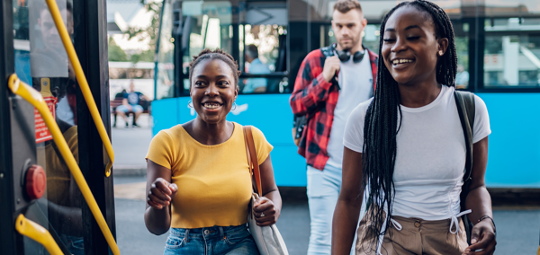 Three teenagers getting on a bus