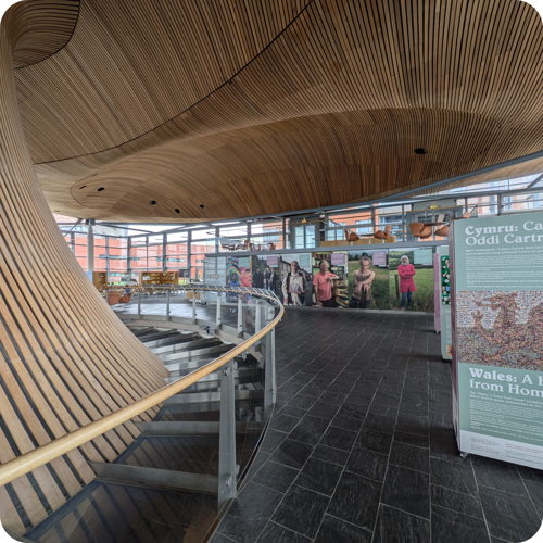 Image shows the Oriel area of the Senedd with an exhibition in the background.