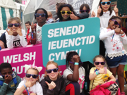 Children holding up Welsh Youth Parliament signs