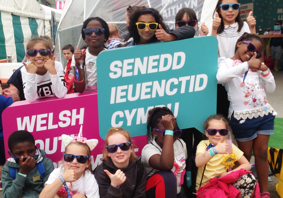 Children holding up Welsh Youth Parliament signs