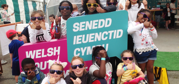 Children holding up Welsh Youth Parliament signs